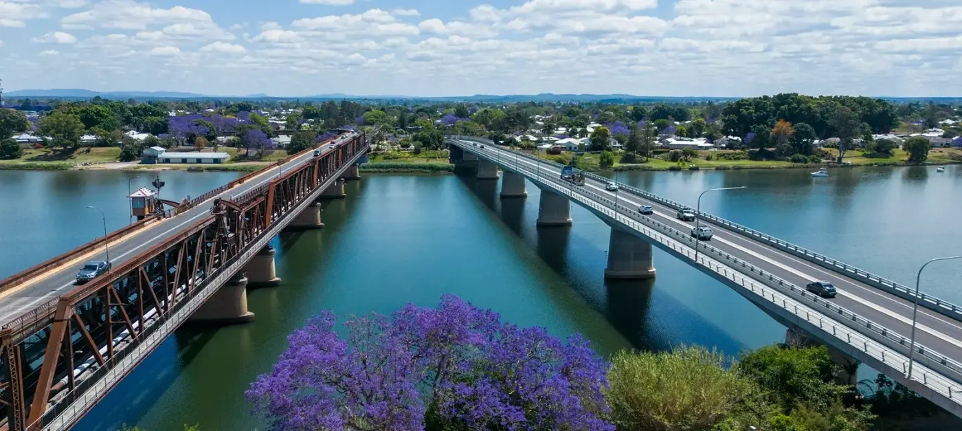 Aerial view of the two Grafton bridges over the Clarence River with jacarandas in bloom